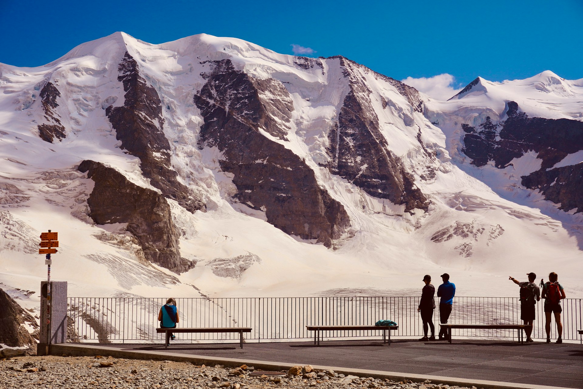 2 person walking on road near snow covered mountain during daytime